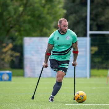 Mark Smith, amputee football player in possession of the ball, looking across the field of play