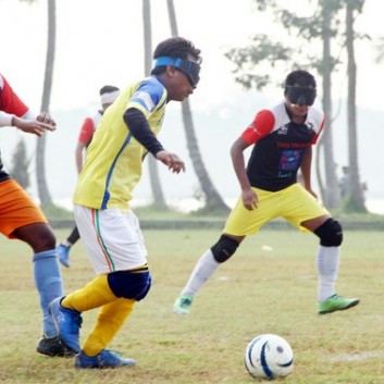 Blind footballer Anthony Samuel takes the ball past an opponent in a training match